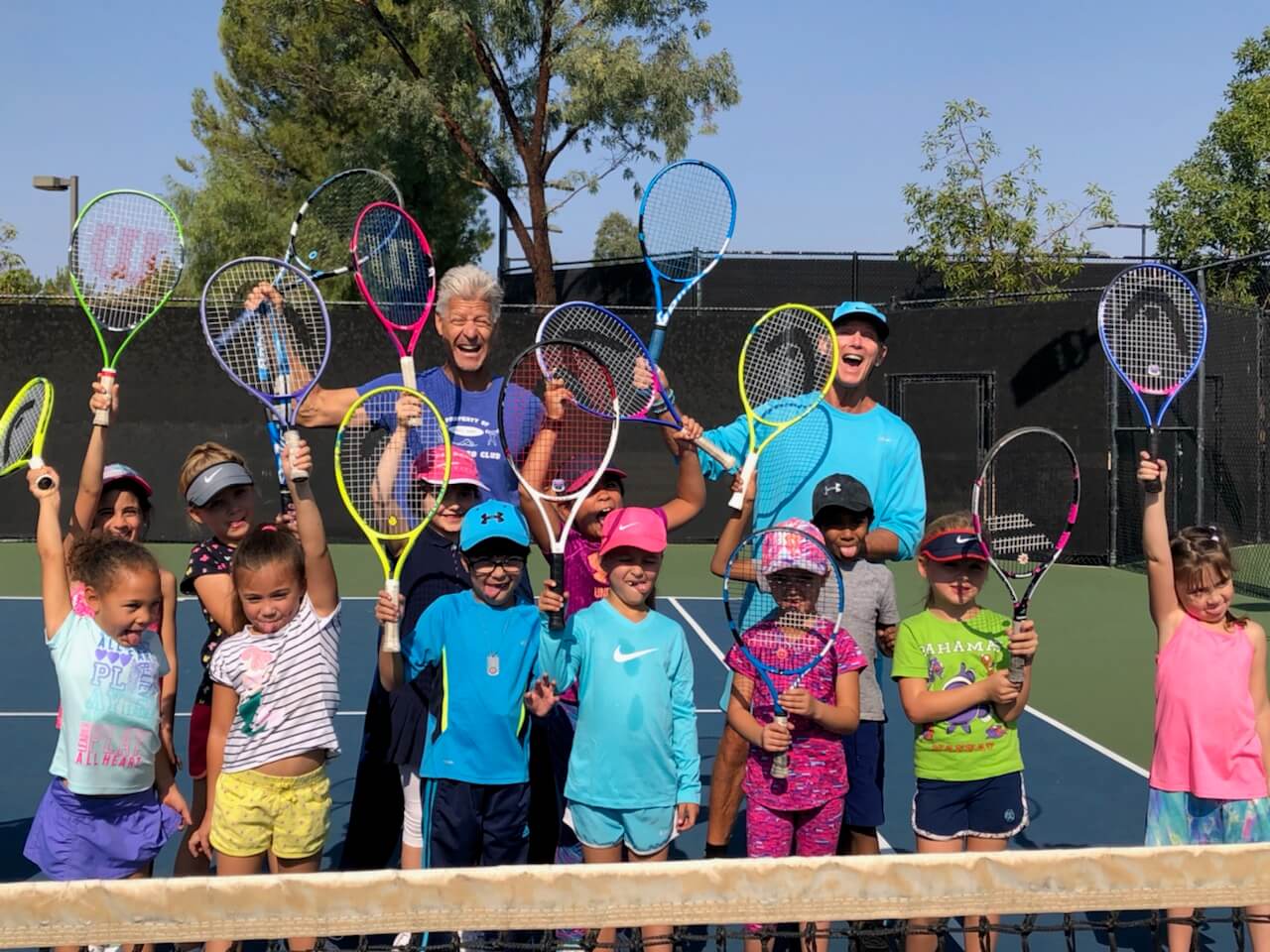 Tennis students with coaches