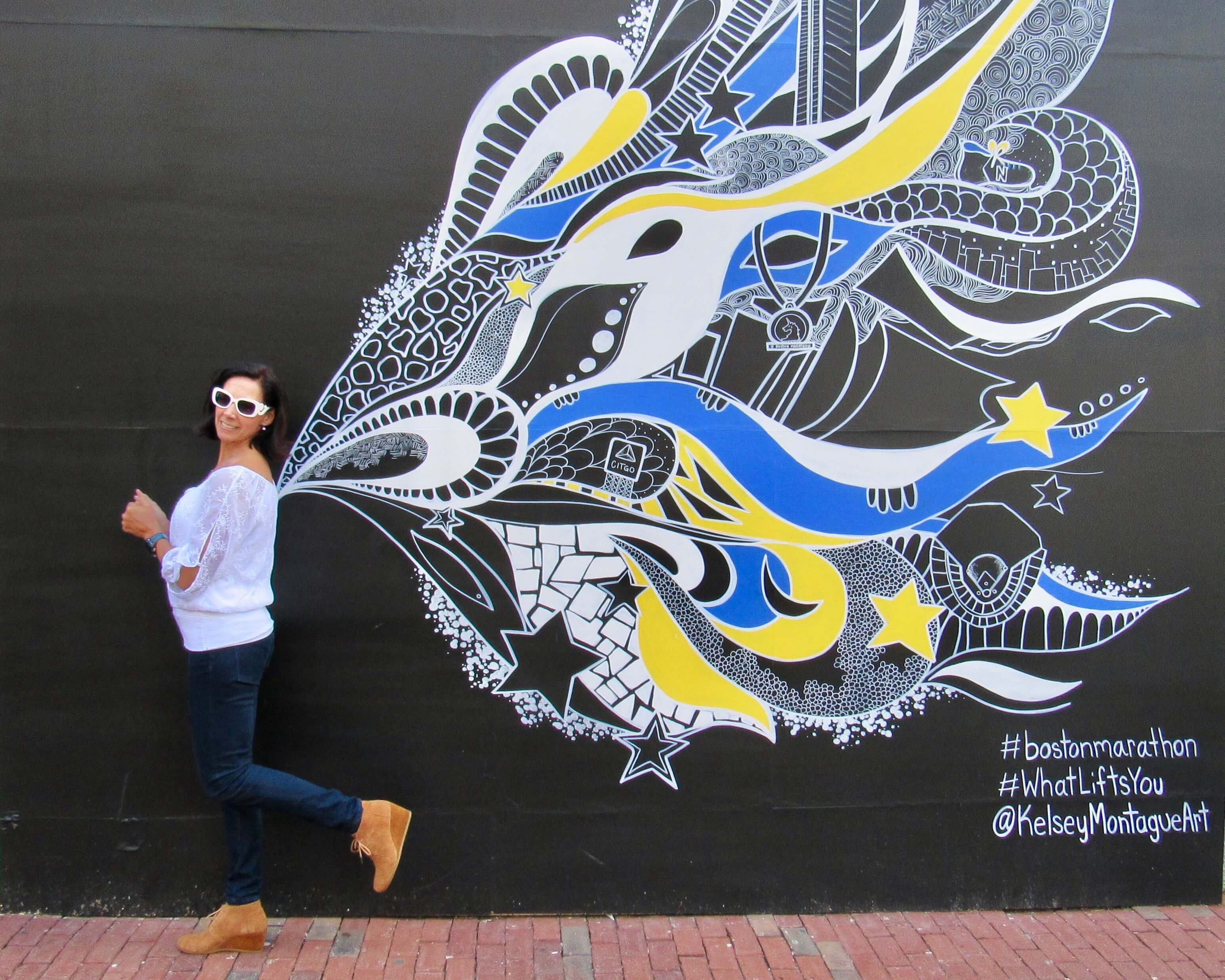 Jodi in front of a mural with butterfly wings