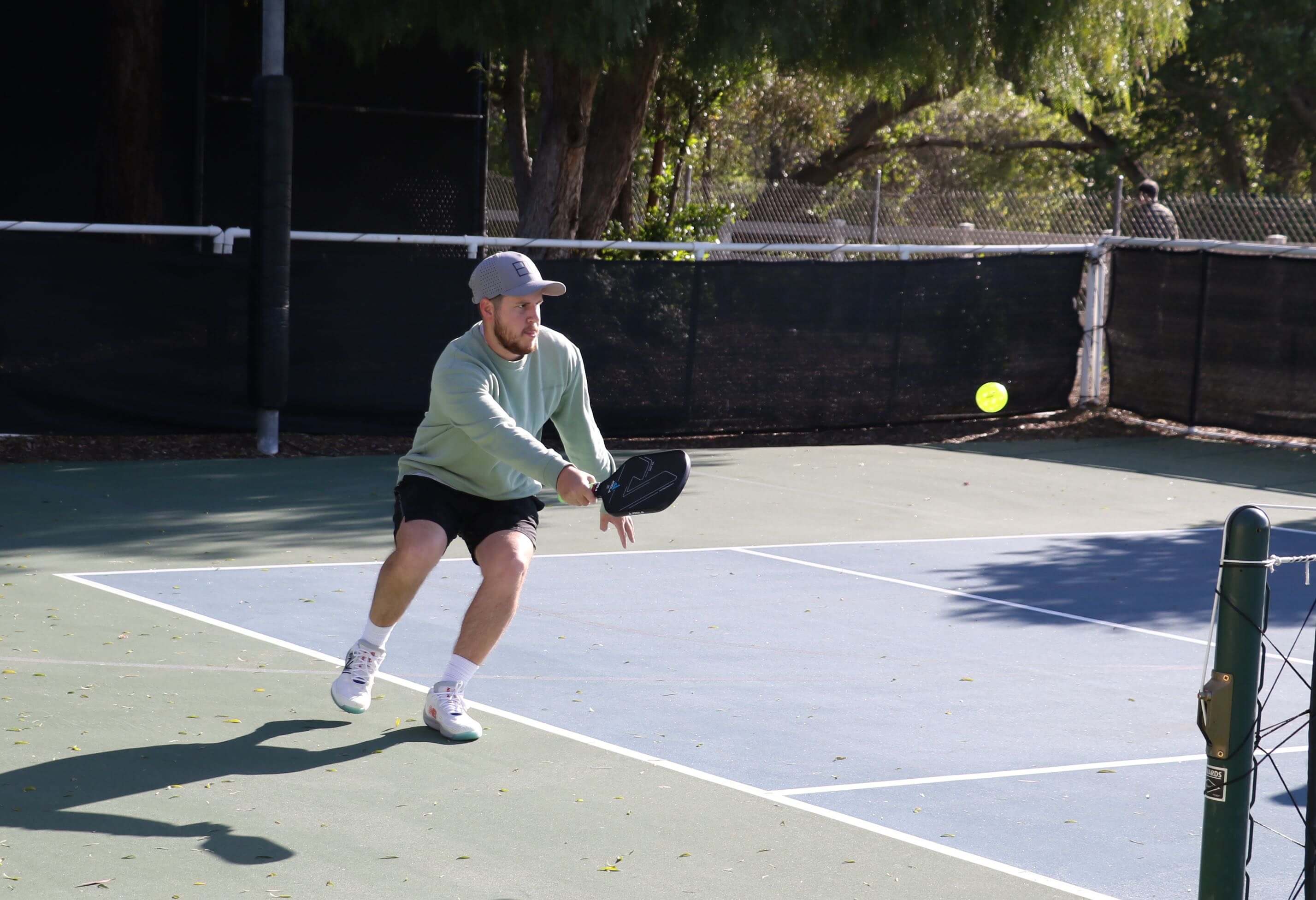 person hitting ball on pickleball court
